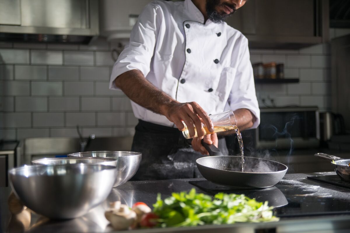 Cuoco che rifinisce un piatto della tradizione in cucina
