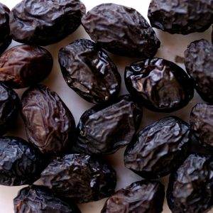 Olive nere infornate in una ciotola di terracotta con rametti d'olivo